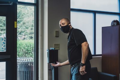 An employee wears a masks and get some hand sanitizer.