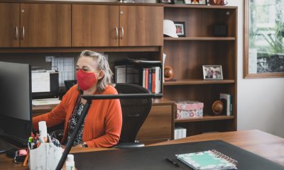 Elaine Gall, UBO, sits at her desk in her office while wearing a mask.