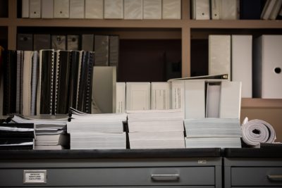 Shelves with stacks of papers, binders, and folders.