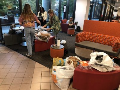 People standing up sorting through plastic bags