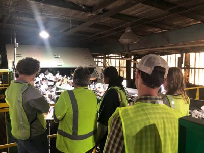 People in safety vests touring recycling facility
