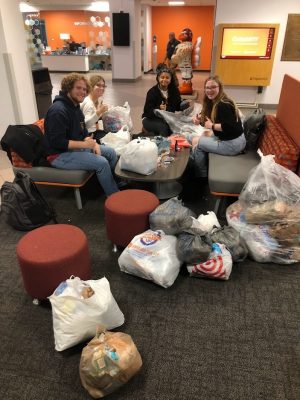 People sitting surrounded by plastic bags