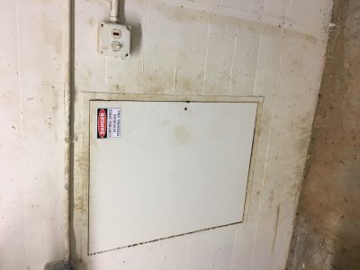 Photo of a confined space door with proper labeling. 