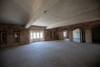 Interior view of a room in War Memorial gym stripped of drywall and flooring.