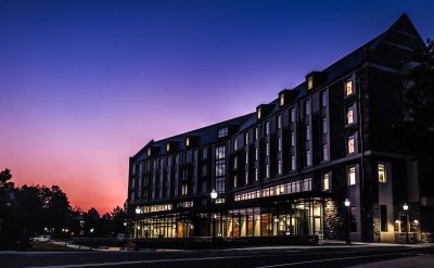 Pink and purple sunrise over a grey hokie stone Creativity and Innovation District LLC building