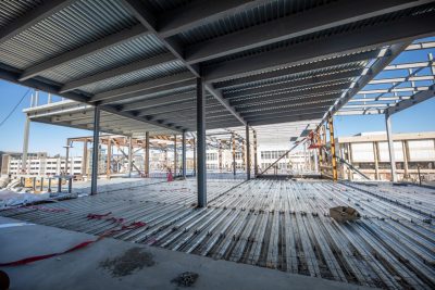 A view looking out from inside Hitt Hall that is under construction. There are steel beams and floors framed out.