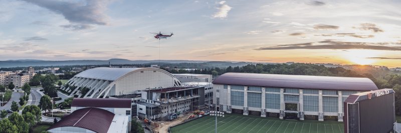 June 23, 2020: A helicopter lifts HVAC units to the roof of the Jamerson Athletic Center at sunrise.