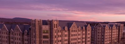 Aerial view of grey hokie stone buildings during a pink sunset on a wintery day