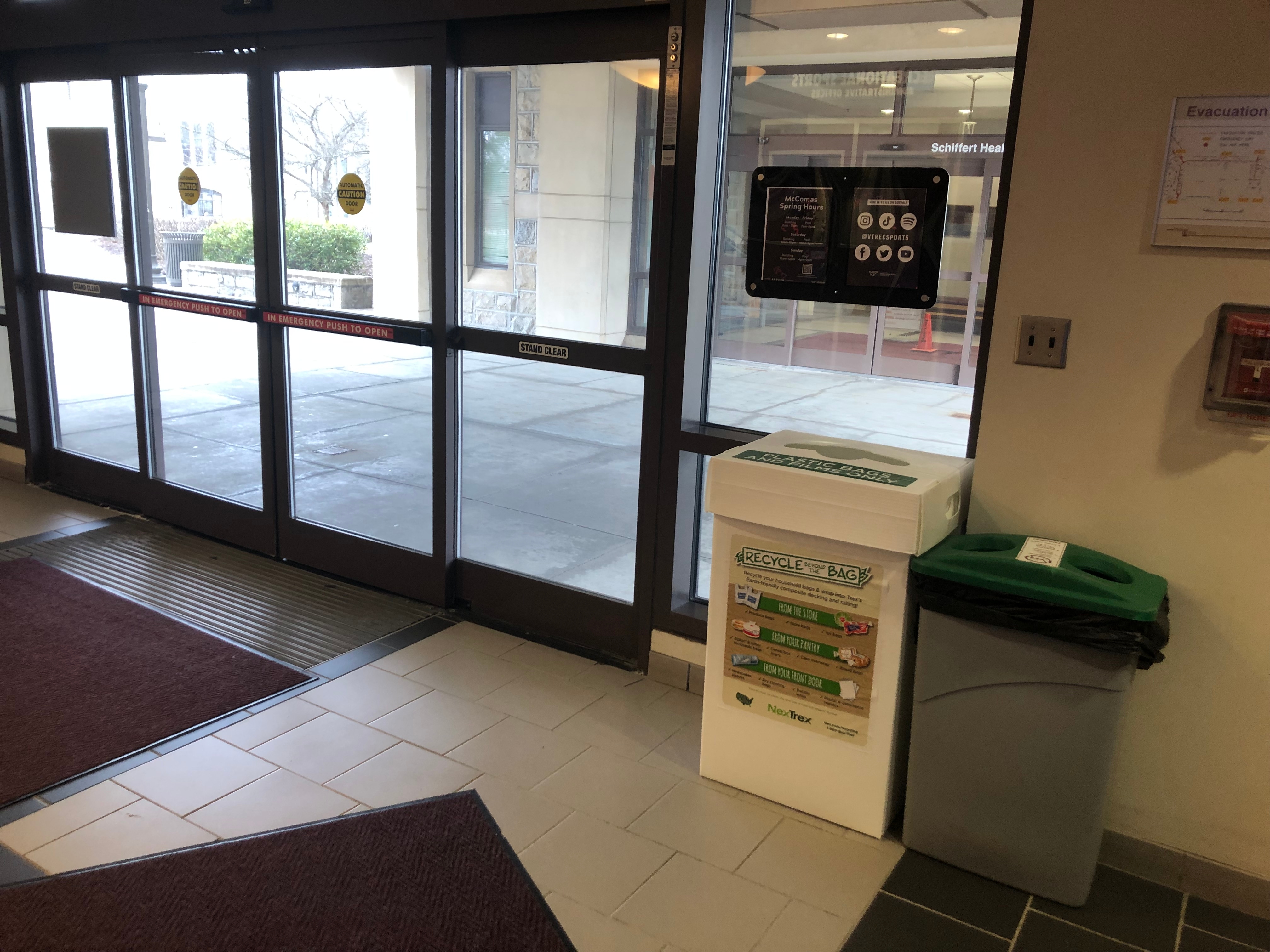 The image shows a NexTrex bin located just inside of the automatic doors to the McComas atrium. 