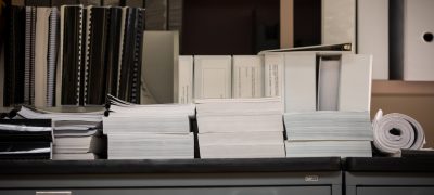 A stack of binders and paperwork on a countertop