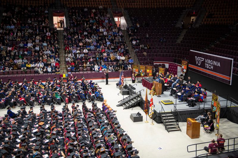 Fall 2019 graduation commencement inside the coliseum with a stage, rows of people in front, and people in the stands.