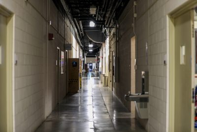 A long hallway with nearly all the lights turned off in it