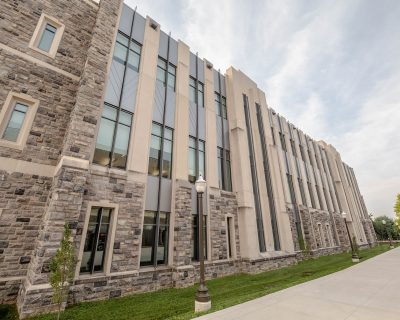 Grey Hokie Stone Classroom Building under cloudy skies. 